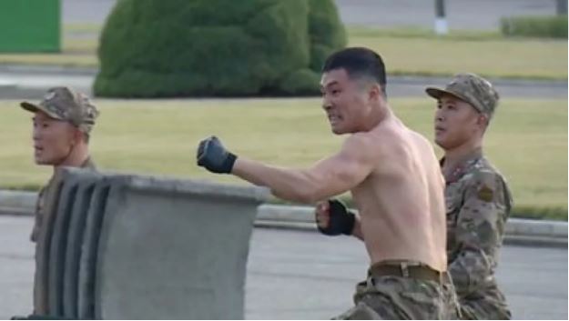 Koreja e Veriut tregon “dhëmbët”, ushtarët thyejnë tulla dhe shtrihen në gota të thyera para Kim Jong Un