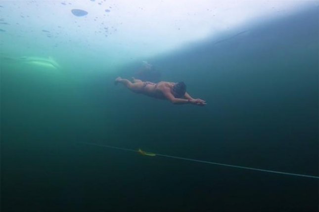 Një grua noton gati 300 metra nën akull për të shënuar Rekordin Botëror Guinness