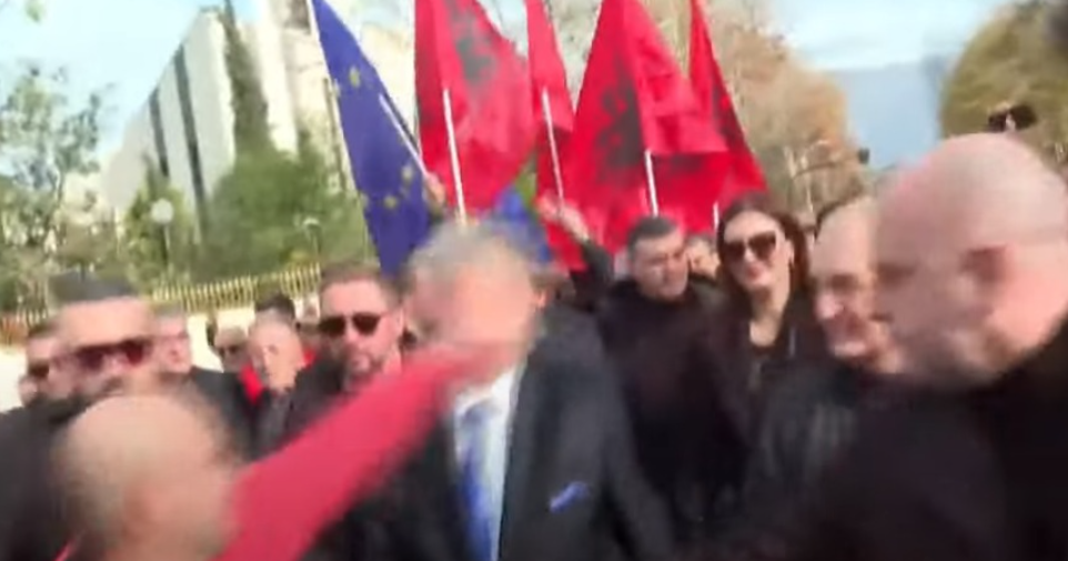 A person punches former premier at the opposition protest