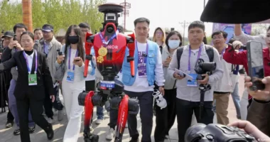 Robotët vrapues ua kalojnë njerëzve në garën në Pekin